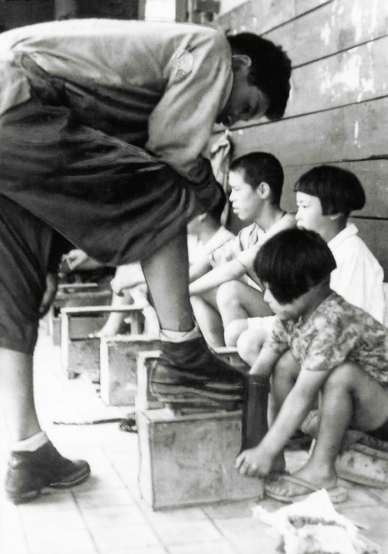 戦後、阪急三宮駅前で靴磨きに精を出す女の子