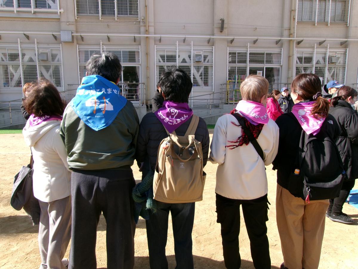手話通訳士と聴覚障がい者のマントによる明示