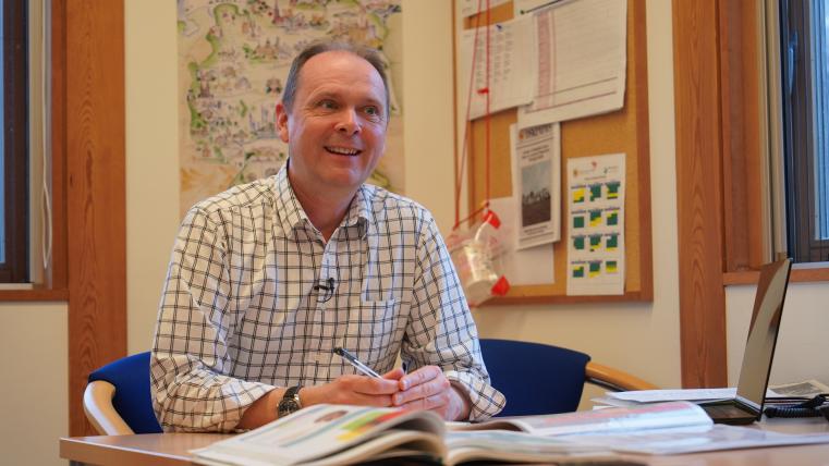 同校の学習環境を説明する学院長アレックス・インマンさんの写真