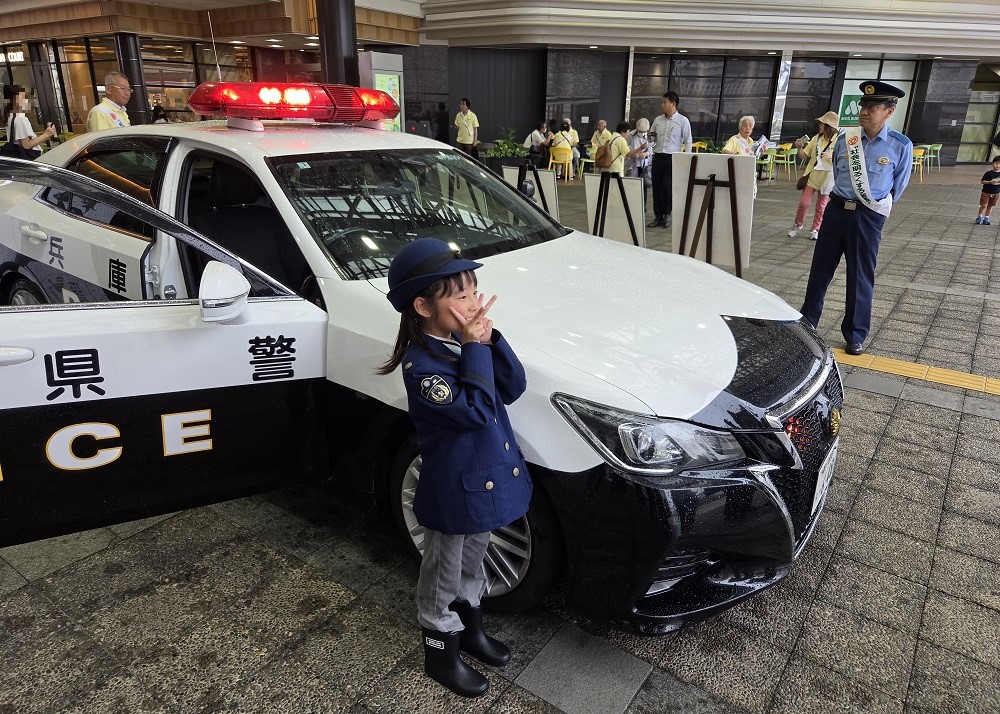 子どもがパトカーと写真を撮る様子